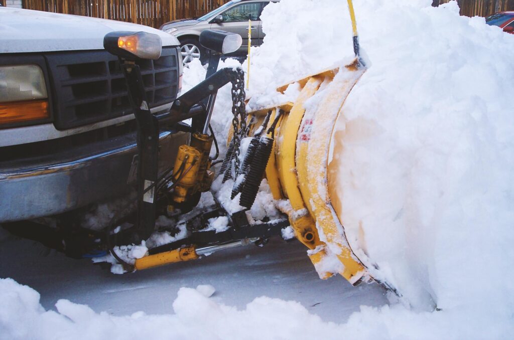 Close up of truck with snow plow attachment demonstrating Snow Removal with Plowing before Salting